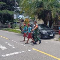 Peduli Keselamatan Anak Sekolah, Secara Rutin Babinsa Koramil Jajaran Kodim 1710/Mimika Bantu Seberangkan Jalan