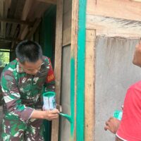 Dan SSK Satgas TMMD Bantu Pengecatan Kusen Pintu RTLH di Kampung Linggang Amer